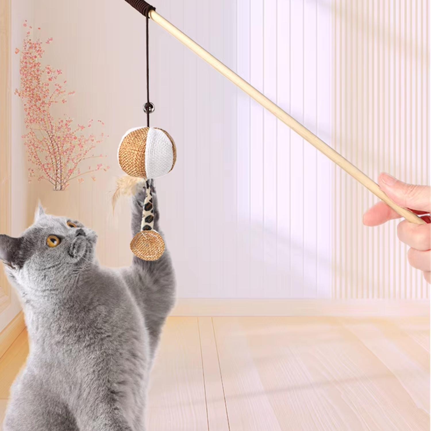 grijze kat speelt met hangende linnen bal